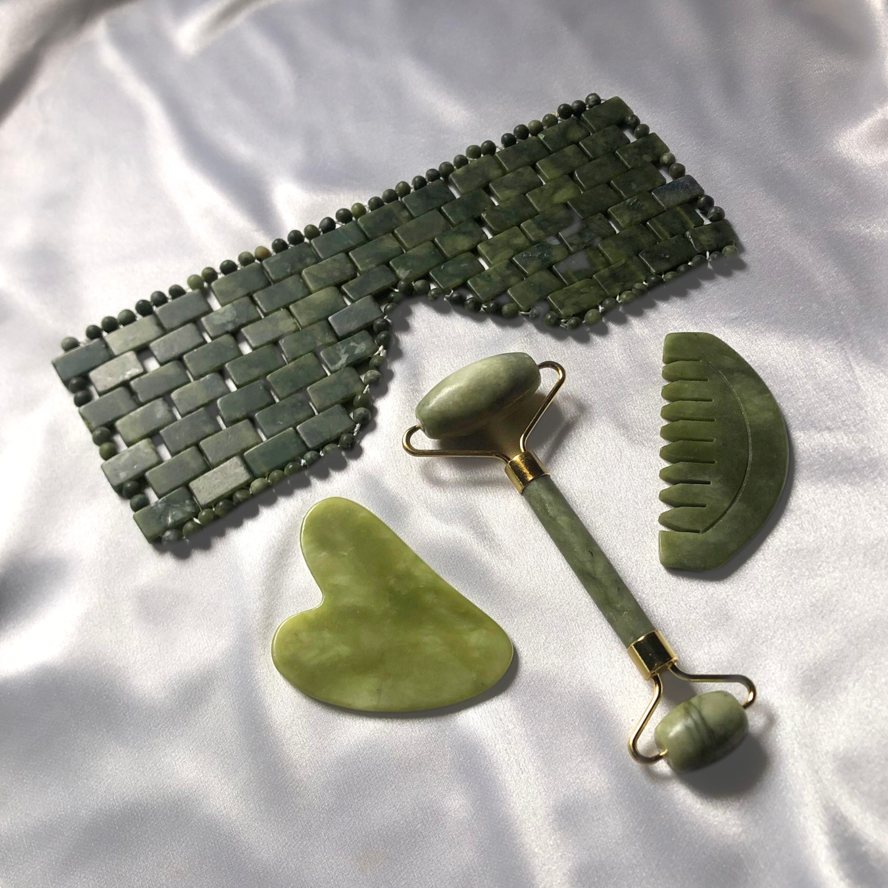 4 in 1 Jade Self Care Kit includes pro jade gua sha stone by Auraé Beauty, jade gua sha comb, jade roller and jade eye mask