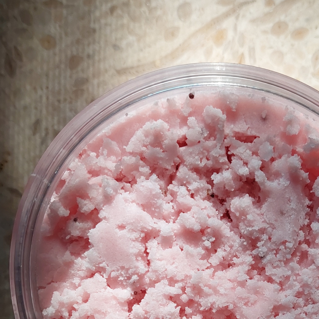 Close-up of pink velvet body scrub in a container to show its texture