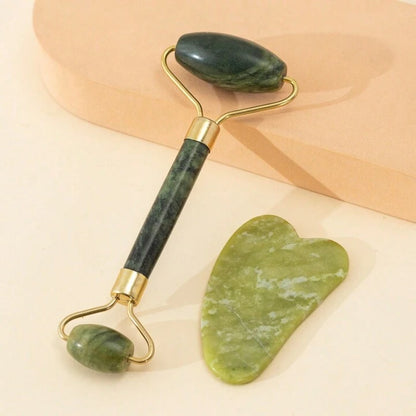 A set of jade facial massage tools, including a roller and a Gua Sha stone, placed for natural face lifting and face contouring.